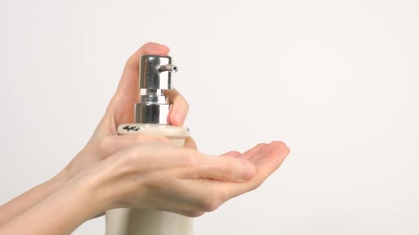 Valkoihoinen nainen painamalla sanitizer geeli pumppu annostelija ja puristamalla pehmeä saippua geeli hänen kämmen
 - Materiaali, video