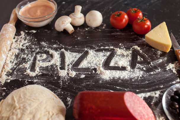 Food concept. Fresh original Italian raw pizza, preparation in traditional style. Making pizza at home. Pizza cooking in a real home interior - 写真・画像