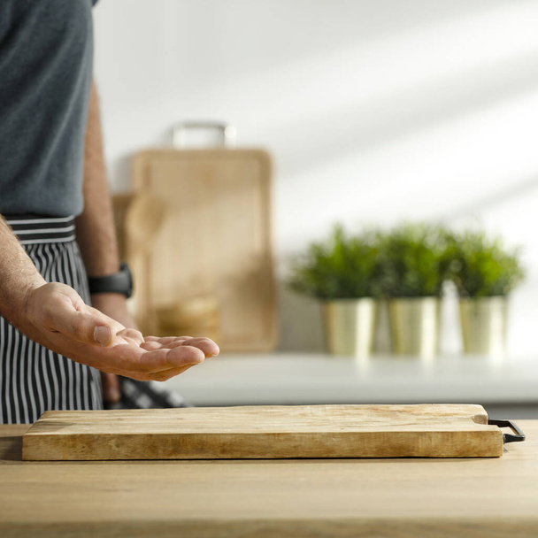 Table background and a male hand in the kitchen - Photo, Image