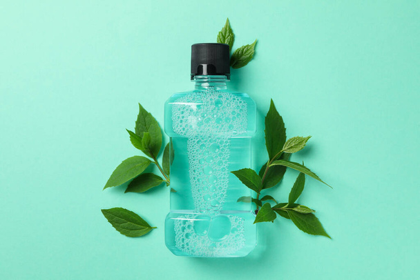 Mouthwash and leaves on mint background, space for text - Fotografie, Obrázek