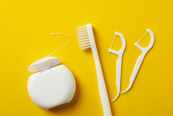 Herramientas para el cuidado dental sobre fondo amarillo, vista superior
 - Foto, imagen