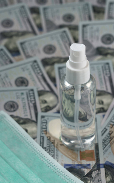 Пляшка для розпилення алкоголю на сотні доларів банкноти та маски для обличчя
 - Фото, зображення