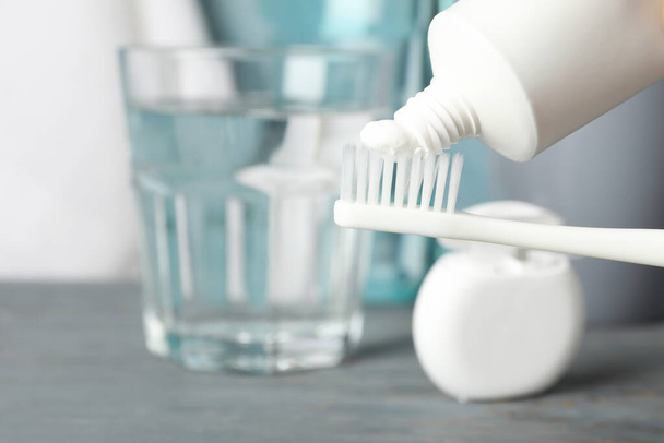 Cepillo de dientes con pasta de dientes en el fondo con herramientas de cuidado dental, de cerca
 - Foto, Imagen