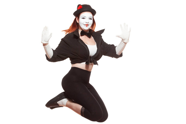 Portrait of female mime artist performing, isolated on white background. Woman jumps very high smiling - Fotó, kép