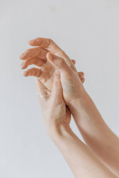 mujer se lava las manos sobre un fondo blanco
 - Foto, imagen