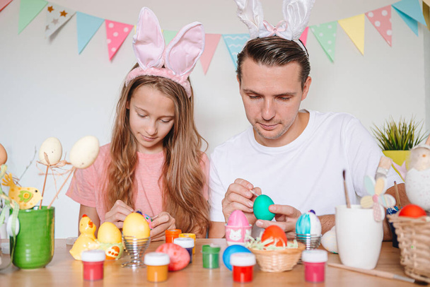Ο πατέρας και η κορούλα του βάφουν αυγά. Ευτυχισμένη οικογένεια προετοιμάζεται για το Πάσχα. - Φωτογραφία, εικόνα