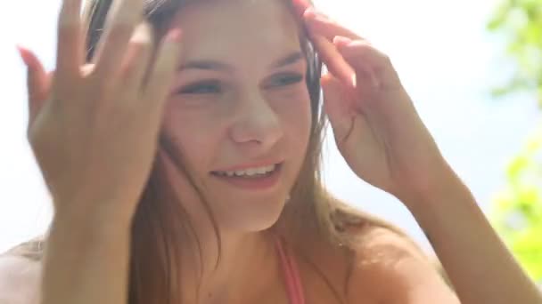 Girl in a pink bathing suit, portrait video. Emotions in the frame, smile, seriousness, sexuality. Bright glare of the sun in the frame. - Footage, Video