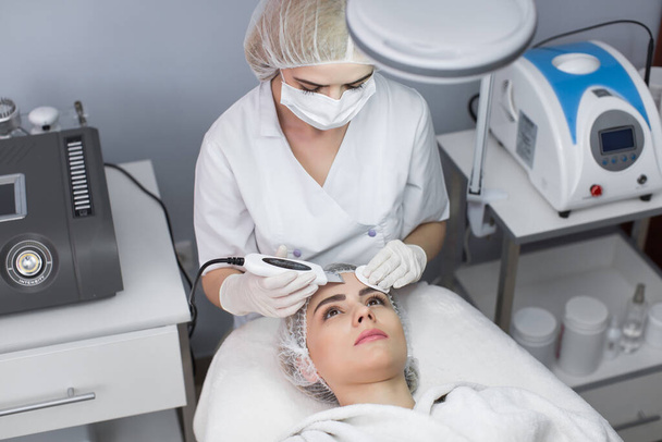 Skin Care. Close-up Of Beautiful Woman Receiving Ultrasound Cavitation Facial Peeling. Ultrasonic Skin Cleansing Procedure. Beauty Treatment. Cosmetology. Beauty Spa Salon. - Foto, afbeelding