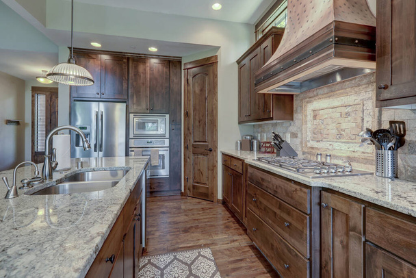 Luxus sötét fa gazdag konyha belső réz tűzhely motorháztető és szürke természetes kő backsplash. - Fotó, kép