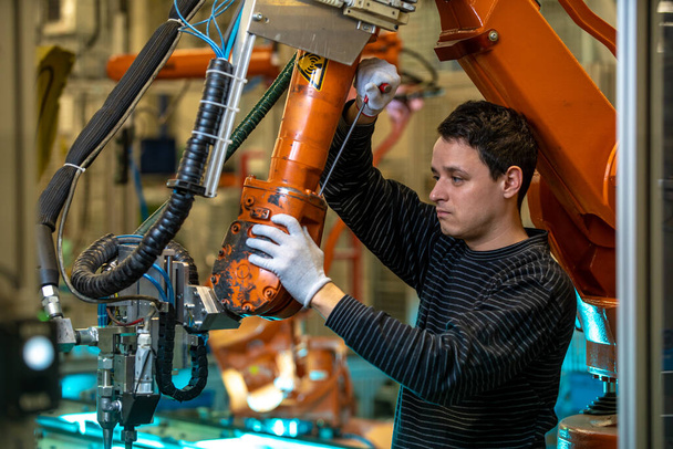 concept Industry 4.0 L'uomo regola il braccio robot per il nuovo programma di produzione
 - Foto, immagini
