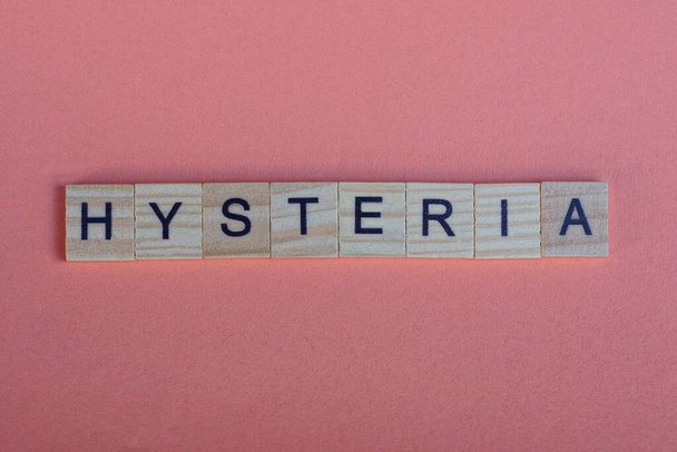 word hysteria from small gray wooden letters lies on a red background - Photo, Image