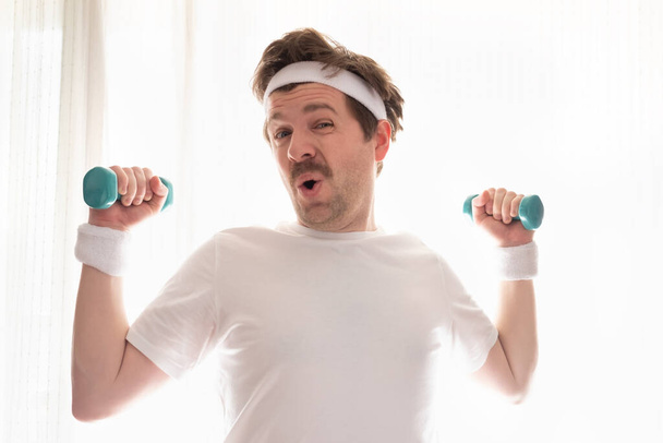 Vicces érett férfi edz otthon gazdaság súlyok - Fotó, kép