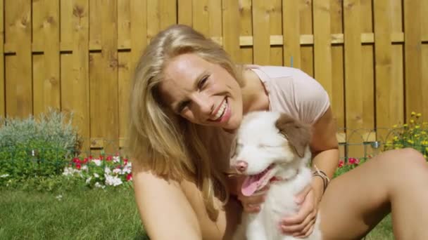 PORTRAIT: Smiling woman pets her cute fluffy white puppy while looking at camera - Footage, Video