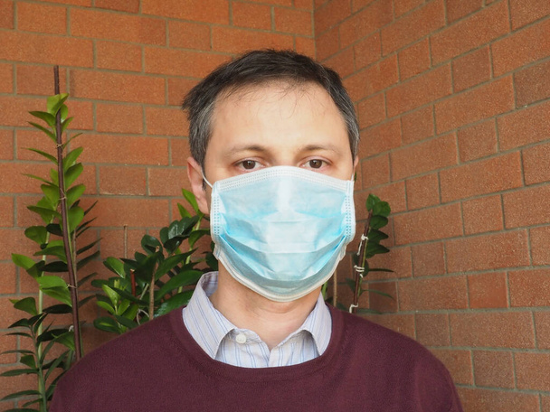 Man with surgical mask used to stop spreading Covid-19 infection - Photo, Image
