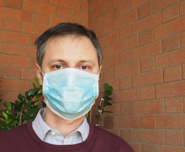 Man with surgical mask used to stop spreading Covid-19 infection - Zdjęcie, obraz