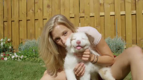 Ritratto: Donna felice gode di una giornata estiva mentre gioca con il suo giovane cane. - Filmati, video