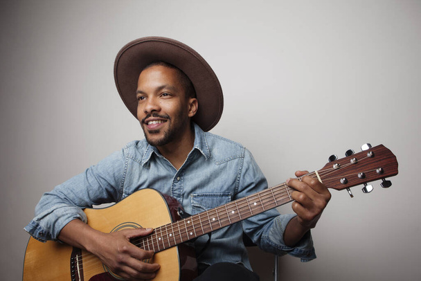 Portrait of happy bearded black man playing guitar isolated on white background. - Photo, Image