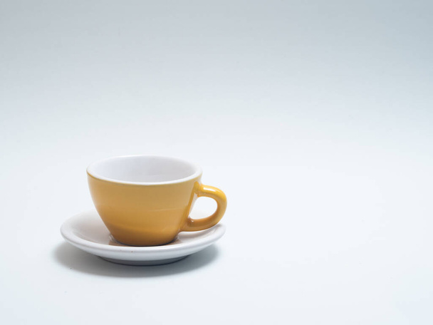xícara de café amarelo em um fundo branco com espaço para cópia
 - Foto, Imagem
