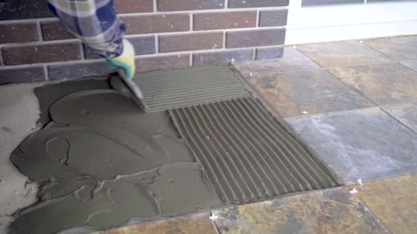Укладка керамической плитки на пол, выравнивание плитки клей с расческой
 - Кадры, видео