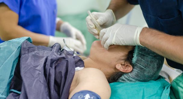 Anestesialääkäri soveltaa endotrakeaalinen putki potilaalle. Pellon matala syvyys
 - Valokuva, kuva