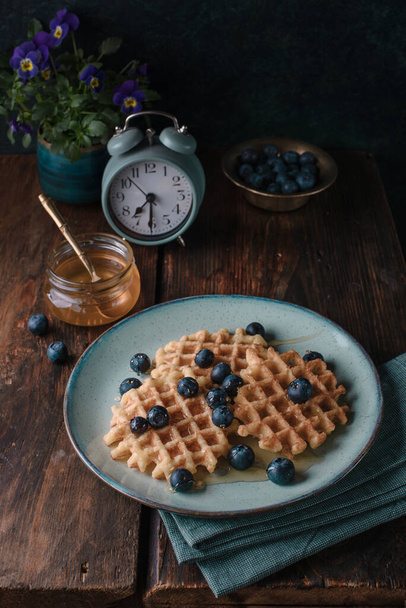 Belgian waffles with blueberry and honey for breakfast - Fotó, kép