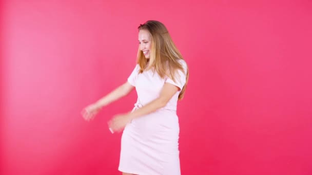 Cheerful woman dancing over red background - Filmati, video