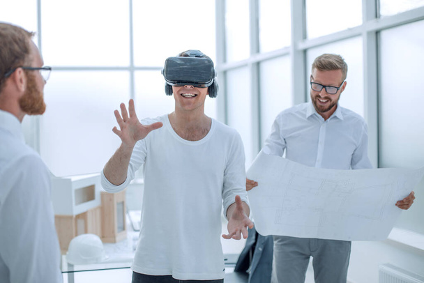 young designer in virtual reality helmet standing in architectural office - Foto, Imagen