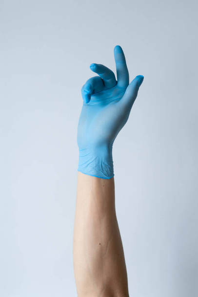 Рука жінки азіатські п'ять пальців символ з рукавичкою лікаря ізольовані на білому тлі
 - Фото, зображення