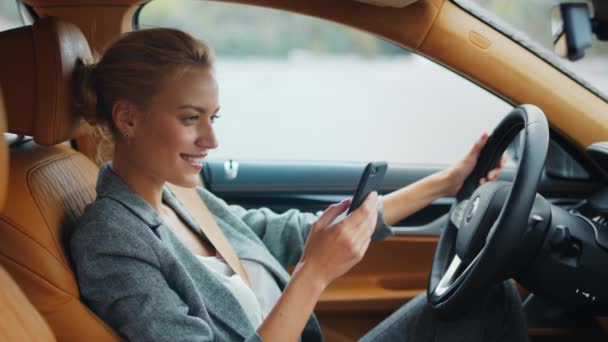 Side view of woman holding phone at car. Businesswoman sitting with phone at car - Footage, Video
