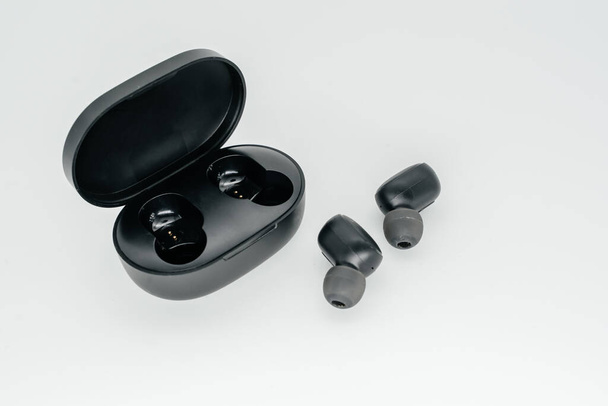 Fones de ouvido Bluetooth em um fundo leve close-up. Vista lateral
 - Foto, Imagem