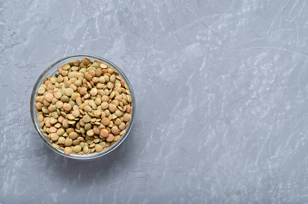 cereals. lentils in a glass bowl on a gray background with place for text. healthy food template. veganism. lean food. - Photo, Image