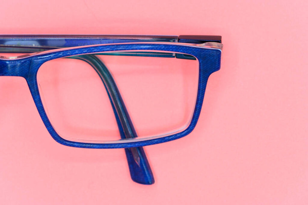 Primer plano de gafas azules sobre fondo rosa, vista superior
. - Foto, Imagen