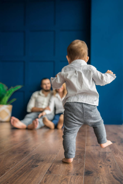 little baby walks barefoot on the floor to parents - 写真・画像