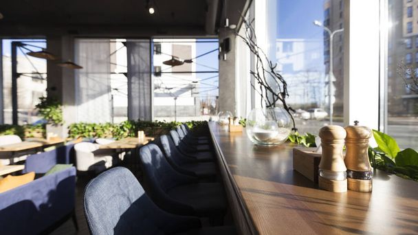 Zonnige ochtend in modern café met grote panoramische ramen - Foto, afbeelding