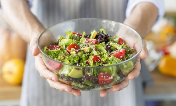 Homme tenant plein bol de salade verte fraîche, panorama
 - Photo, image