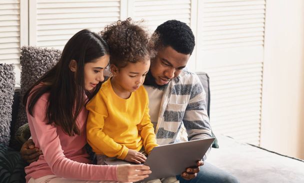 International family looking at tablet at home - Фото, изображение