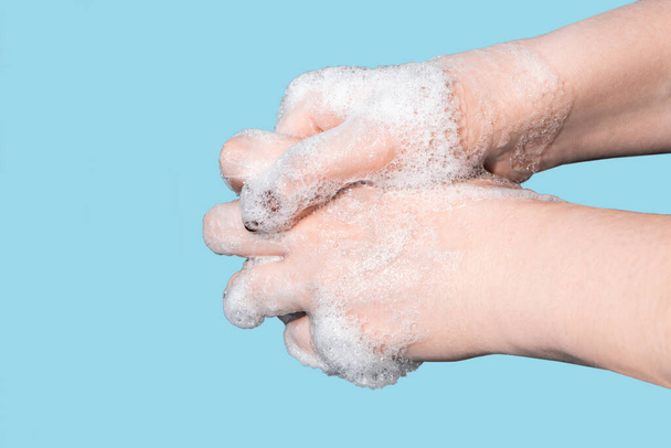 Vaiheittaiset ohjeet käsienpesuun. Nainen pesee ja desinfioi kätensä saippualla sinisellä pohjalla. Koronavirussuoja
.  - Valokuva, kuva