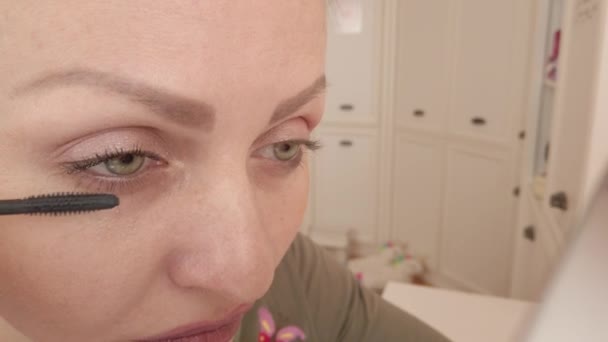 Girl paints eyelashes with mascara - Video