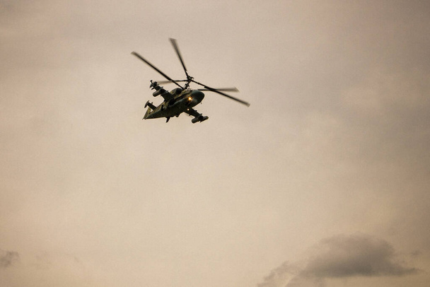No céu nublado um helicóptero militar. Lei marcial, conflito local. Tonificação, vinheta
. - Foto, Imagem