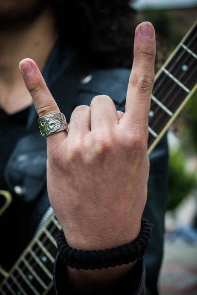 Rocker hand in front of guitar - 写真・画像