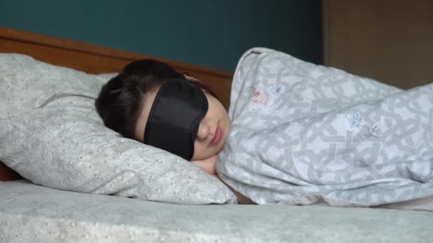Una joven duerme con una máscara para dormir. Una chica se acuesta en su habitación
. - Imágenes, Vídeo