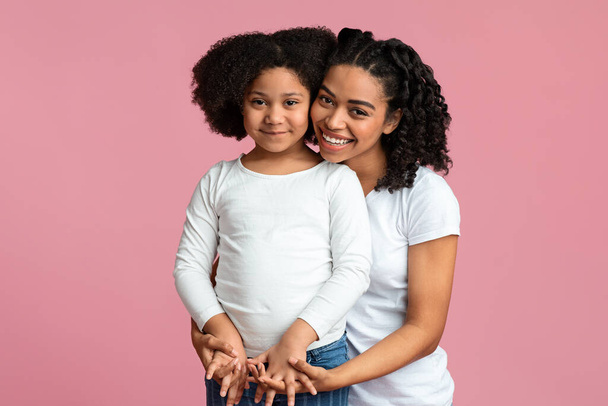 Concept d'adoption des enfants. Heureuse femme noire posant avec sa fille adoptive
 - Photo, image