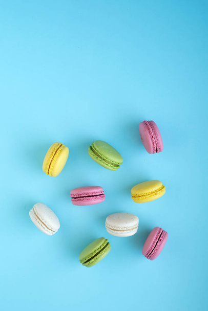 Draufsicht auf bunte französische traditionelle Macarons auf blauem Hintergrund - Foto, Bild
