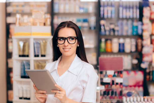 Happy Young Pharmacist Standing Next to Shelves  - 写真・画像