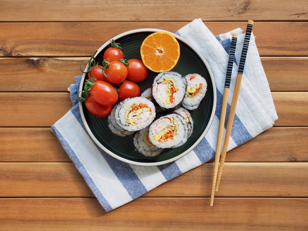 Comida coreana kimbap vegetal y tomate de cereza, mandarina
 - Foto, Imagen