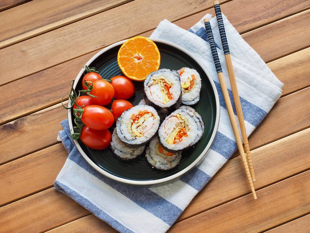Nourriture coréenne Kimbap aux légumes et tomate cerise, mandarine
 - Photo, image