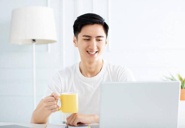 молодий чоловік працює вдома з ноутбуком
 - Фото, зображення