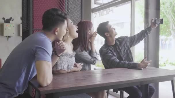Young Asian people chatting and taking selfie while sitting in the restaurant - Video