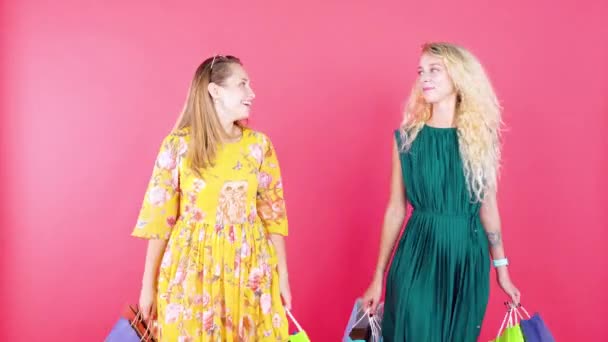  Two young women carries shopping bags in studio - Video, Çekim