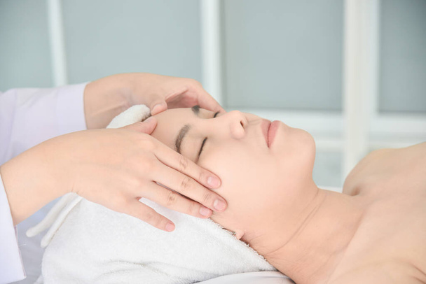 Terapeuta robi masaż Tui na twarzy pacjenta, Chińska medycyna alternatywna. - Zdjęcie, obraz